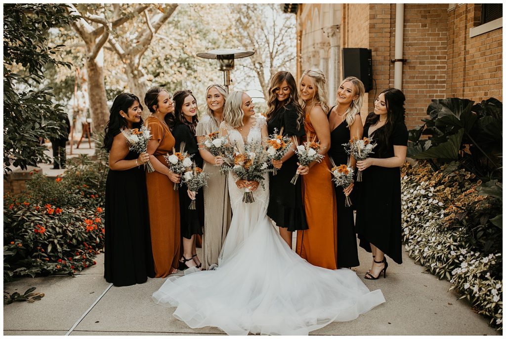bride and bridesmaids wearing burnt orange dresses