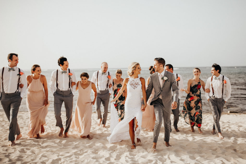 bride and groom with their wedding party on the beach
