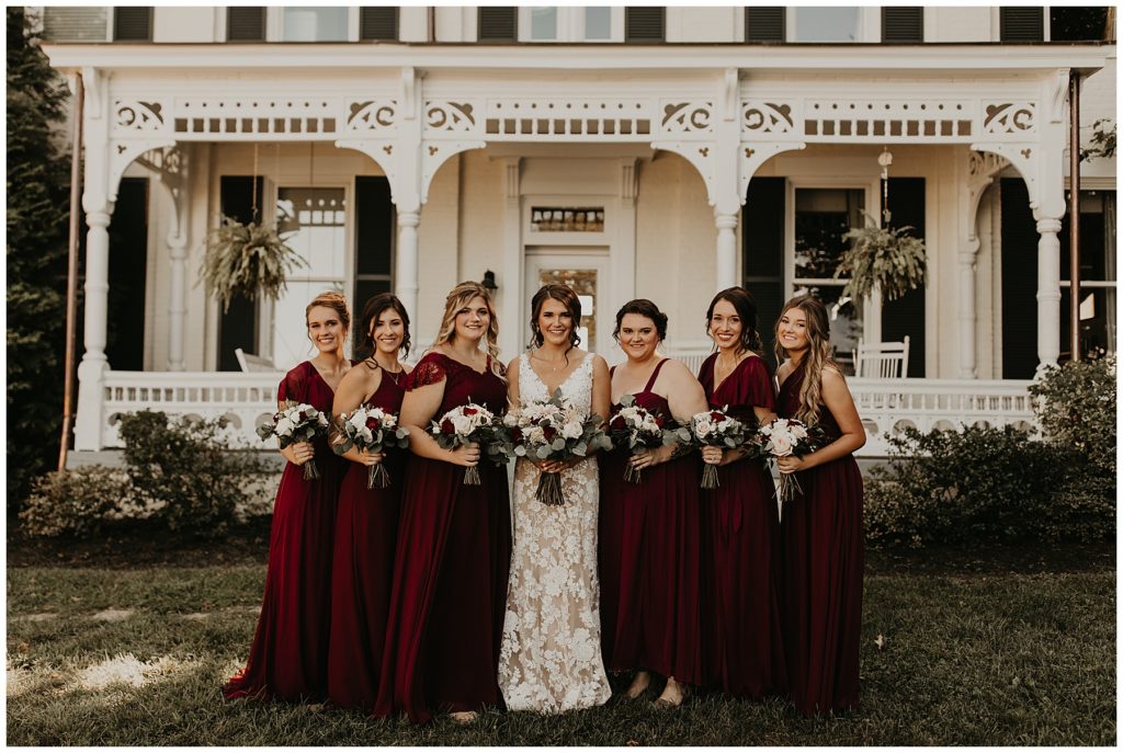bride and bridesmaids at riverside inn bed and breakfast on wedding day. bridesmaids in burgundy dresses