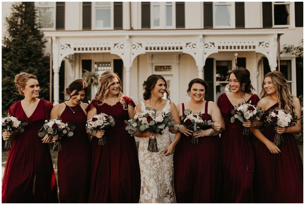 bride and bridesmaids at riverside inn bed and breakfast on wedding day. bridesmaids in burgundy dresses