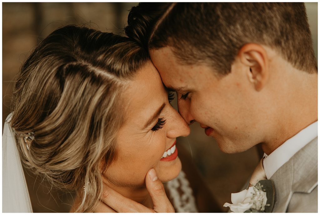 bride in boho lace wedding dress and blush bouquet with king protea and eucalyptus, groom in light grey suit