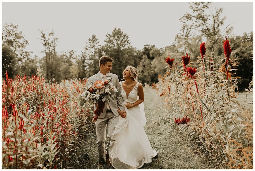 bride in boho lace wedding dress and blush bouquet with king protea and eucalyptus, groom in light grey suit