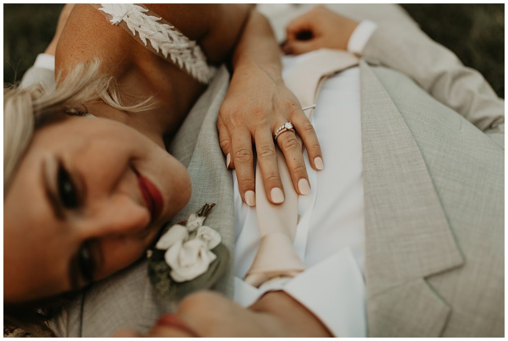 bride in boho lace wedding dress and blush bouquet with king protea and eucalyptus, groom in light grey suit