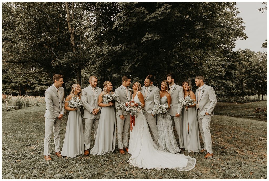 bridal party photo, bride in boho lace wedding dress and blush bouquet with king protea and eucalyptus, bridesmaids in light grey dresses