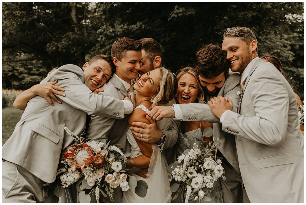 bridal party photo, bride in boho lace wedding dress and blush bouquet with king protea and eucalyptus, bridesmaids in light grey dresses