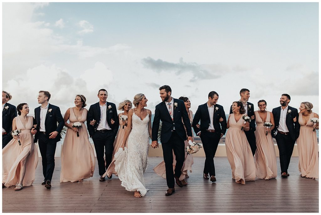 bridal party taking photos on the beach before wedding ceremony in cancun mexico