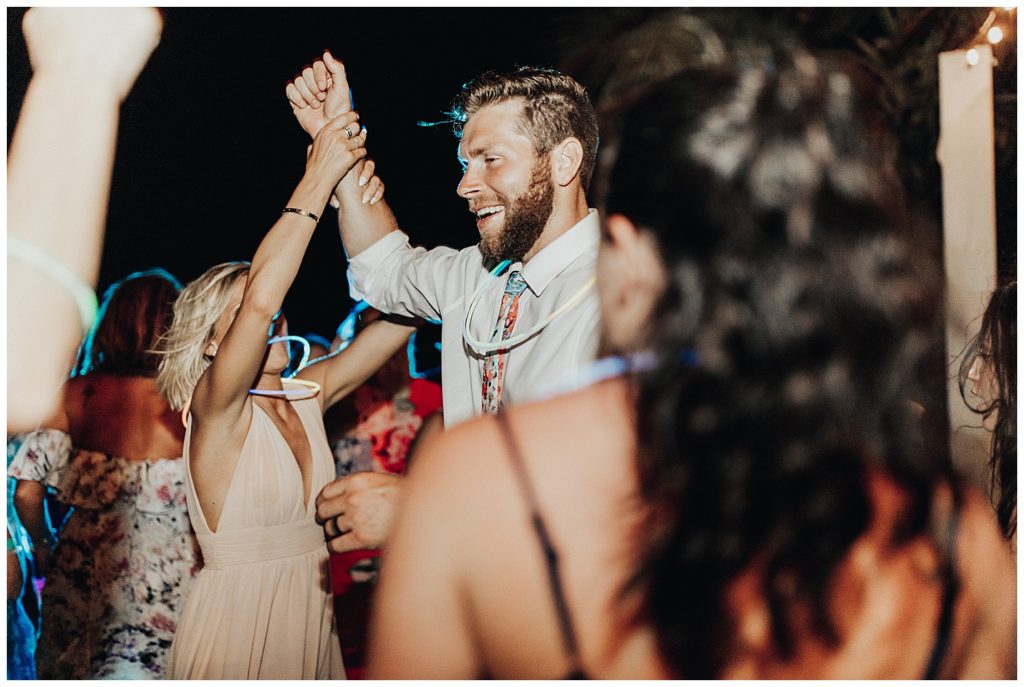 wedding guests dancing and partying on the beach during reception in cancun mexico