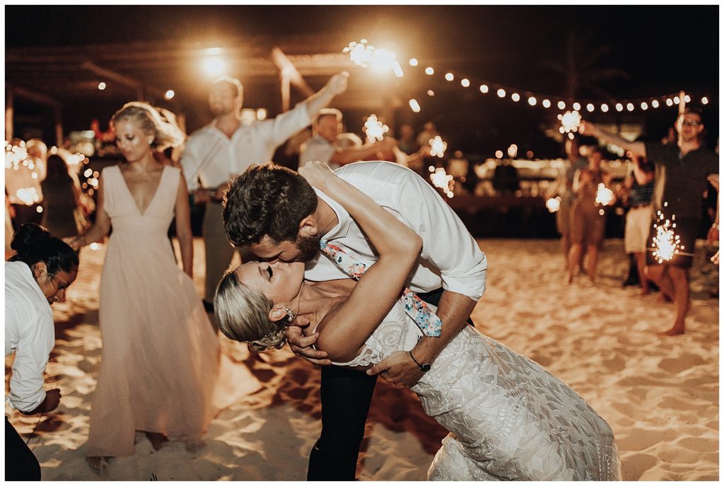 wedding guests dancing and partying on the beach during reception in cancun mexico